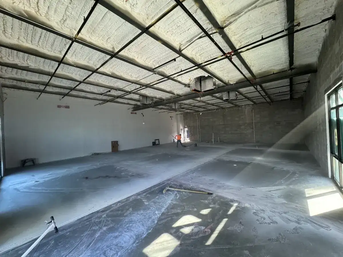 Large interior concrete floor being washed and cured inside a new commercial building